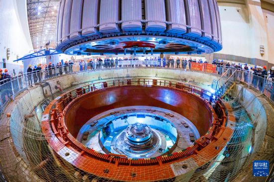 这是11月30日在检修现场拍摄的被起吊的发电机组转子。 新华社记者 周义 摄