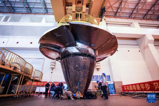 11月30日,检修人员将机组转轮吊装至安装间。新华社记者 周义 摄